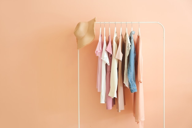 Rack with hanging clothes on pink