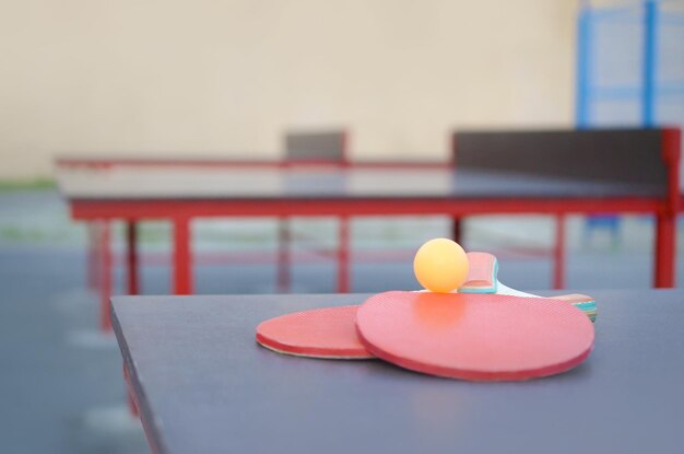 Photo rackets and ball on ping pong table in outdoor sport yard active sports and physical training concept