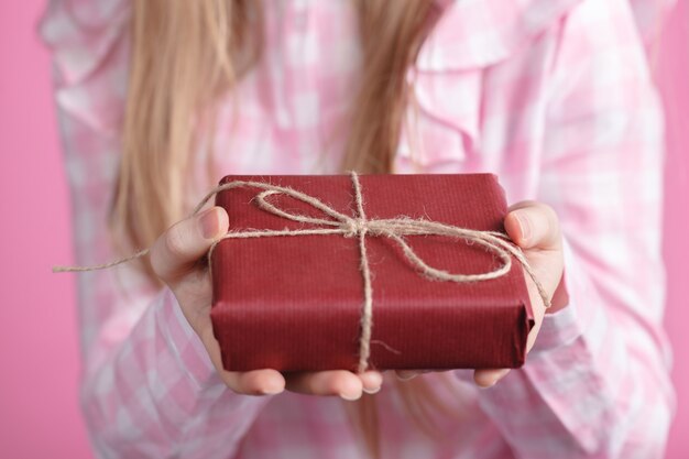 Rad giftbox in female hands in pink