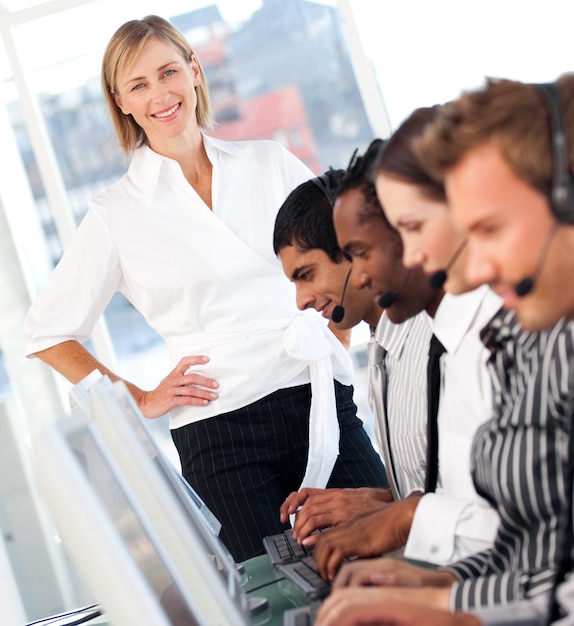 Radiant female leader with a team on a call center