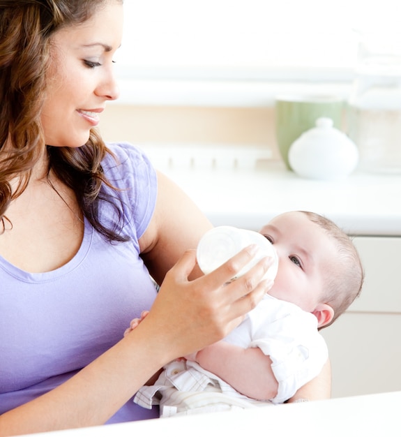 Radiant mother feeding her adorable son in the kitchen