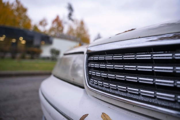The radiator grille of a classic Japanese car in an autumn urban landscape