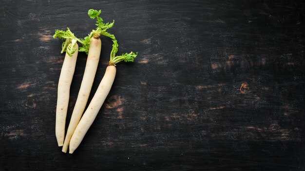 Radijs Daikon op een zwarte achtergrond Radijs Groenten Bovenaanzicht Vrije ruimte voor uw tekst