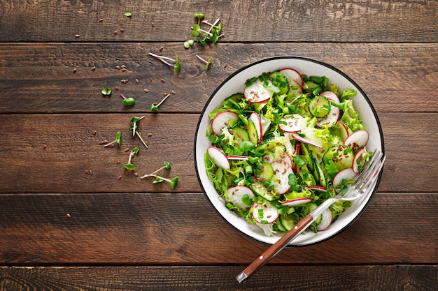 Radijs en komkommersalade met verse groene ui in kom Bovenaanzicht