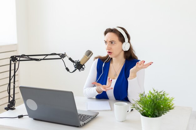 Radio, blogging, podcasting concept - young woman working as a dj on the radio.