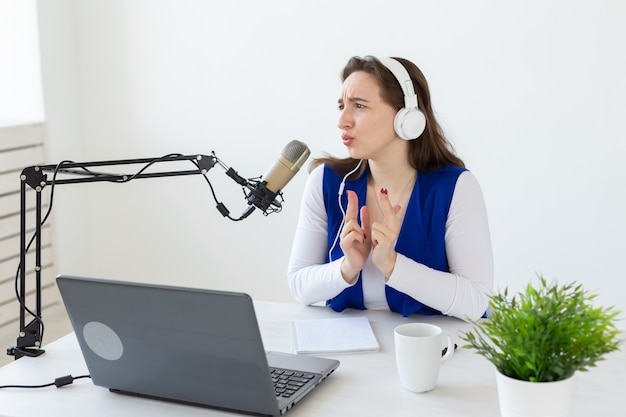 Radio, blogging, podcasting concept - young woman working as a dj on the radio.