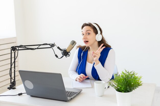 Radio, blogging, concetto di podcasting - giovane donna che lavora come dj alla radio.