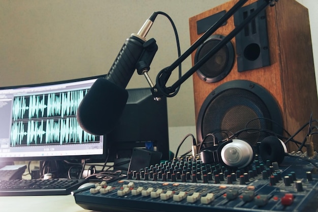 Foto microfono host radiofonico colonna sonora della console di missaggio e cuffie sullo sfondo del monitor di un computer radio studio