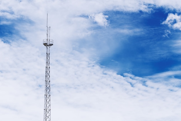 Radio signal communication tower on dramatic blue sky with space for text