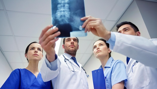 Foto radiologie, gezondheidszorg, mensen, chirurgie en geneeskundeconcept - groep artsen die naar röntgenscanbeeld kijken