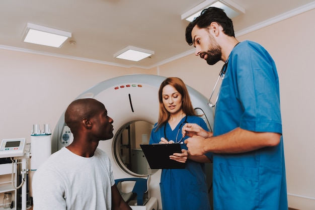 Photo radiologist and afro man near mri or ct machine.