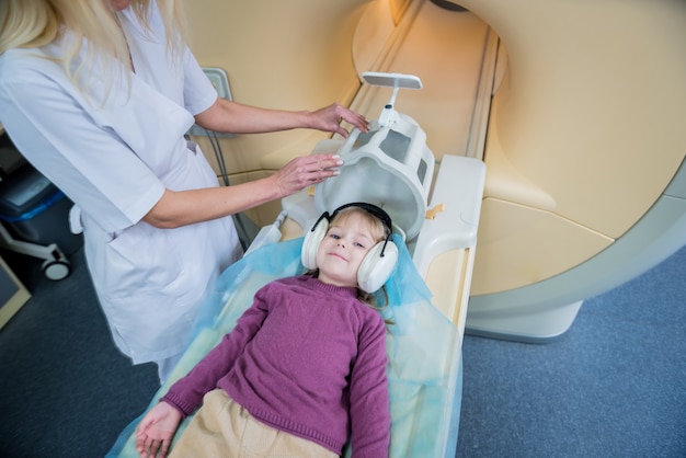 Radiologist prepares the little girl for an MRI brain examination