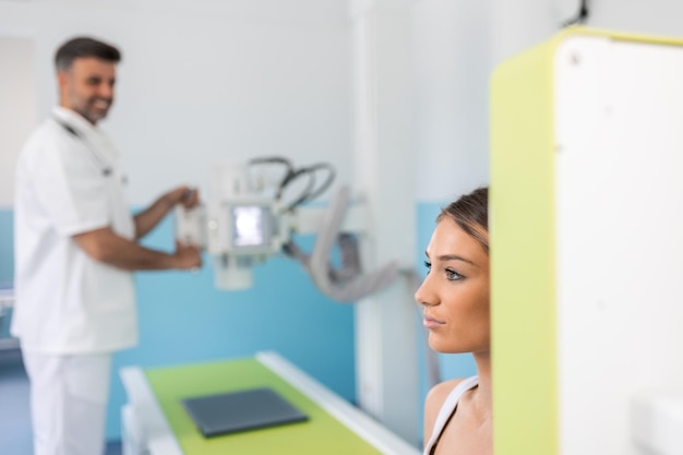 Radiologist setting up the machine to xray female patient Radiologist and patient in a xray room Classic ceilingmounted xray system Medical equipment