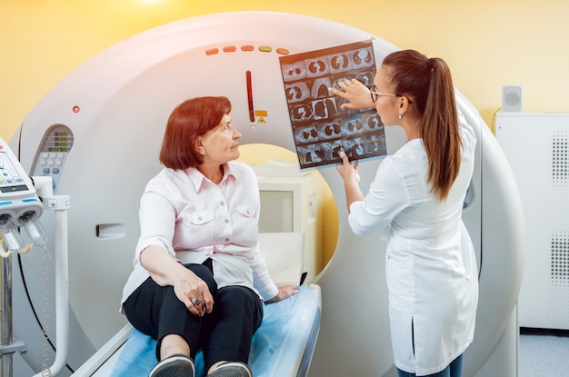 X線を見る高齢の女性患者の放射線科医。