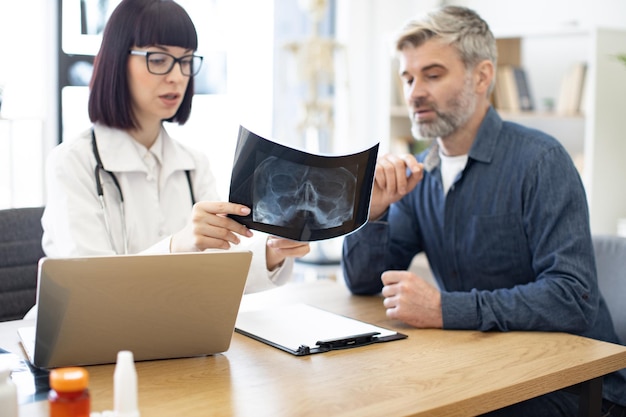 Radiologist with laptop explaining xray changes to patient