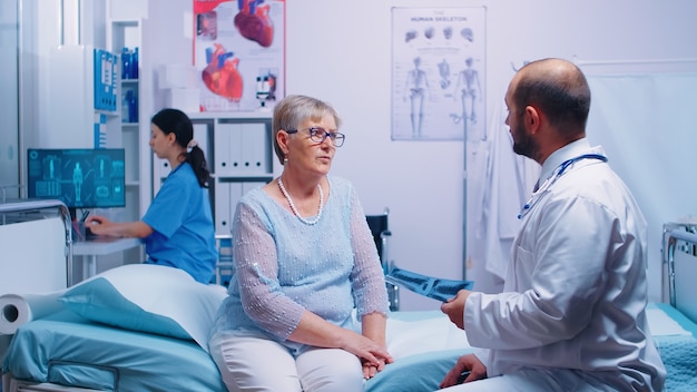 Radiology office specialist looking at X ray of old retired senior woman in private clinic or hospital. Health care screen medical medicine diagnosis of illness treatment. Pneumonia lungs virus screen