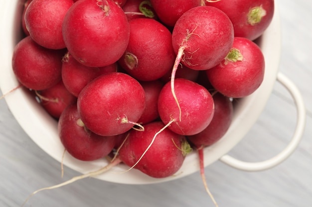 Radish - red radishes in bowl on wooden table