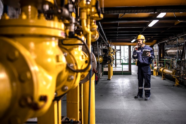 Raffinaderijarbeider die de productie van ruwe olie in de fabriek controleert