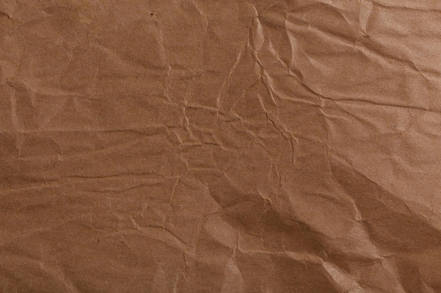 Текстура рваной мятой коричневой крафт-бумаги и полный фон кадра