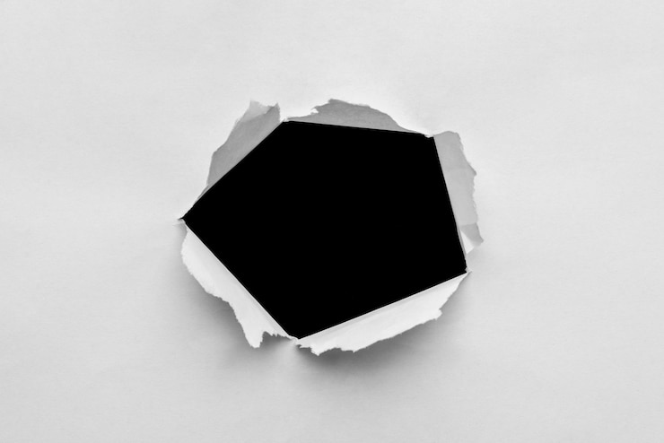 Photo 黒の背景に紙に引き裂かれたぼろぼろの穴