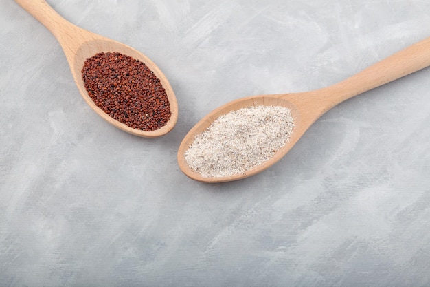 Ragi or Nachni also known as finger millet and ragi flour in wooden spoons on grey table