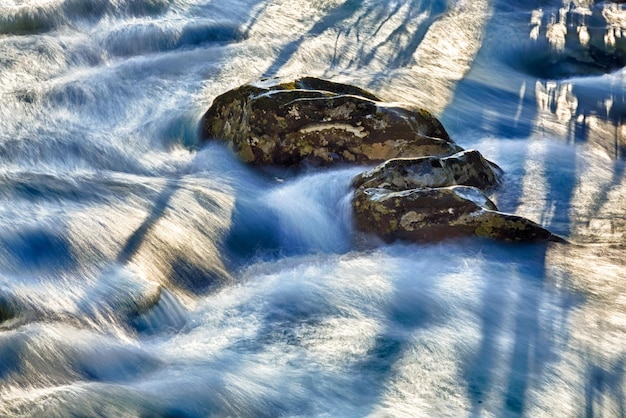 Photo raging river flows around rocks