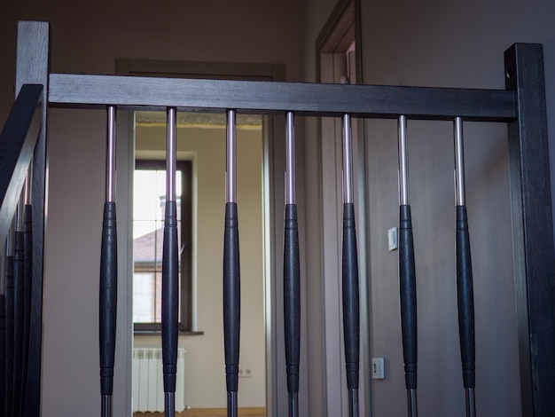 Railing of a wooden staircase overlooking the room and the window