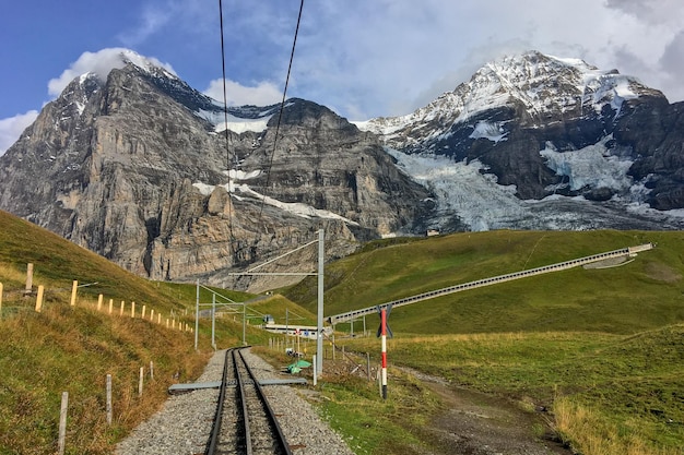 Foto traccia ferroviaria in mezzo a montagne innevate contro il cielo