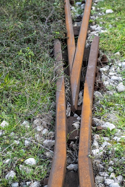 A railroad track has rusted metal bars on the bottom and the word " stop " on the bottom.