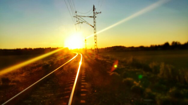 Foto i binari della ferrovia contro la luce del sole