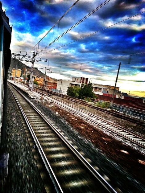 写真 雲の空に沿った鉄道線路