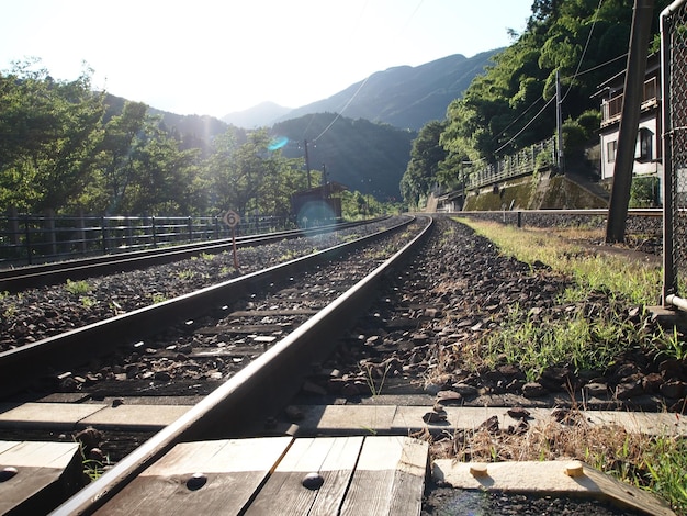 Railroad tracks against mountains on sunny day