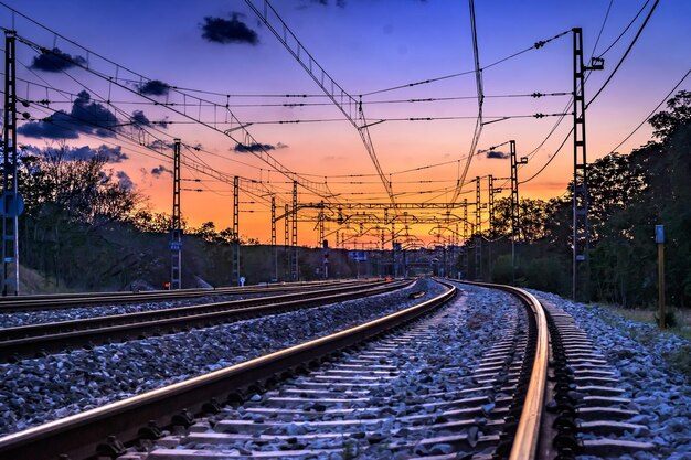 Photo railroad tracks against sky at sunset