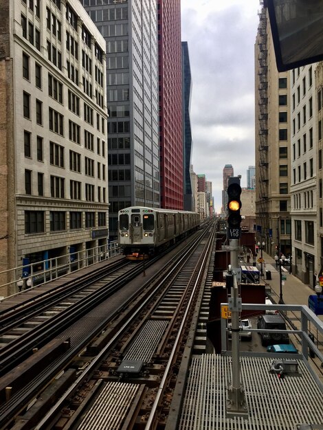 Photo railroad tracks amidst buildings in city against sky