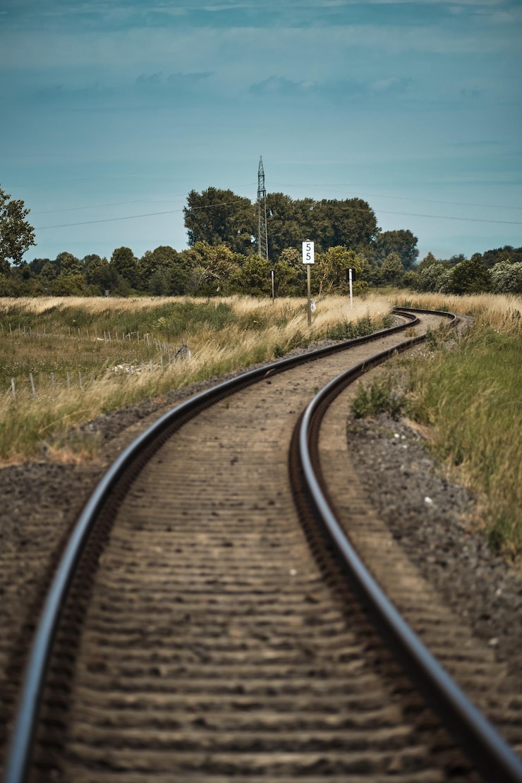 Photo 空に照らされた畑の中の鉄道線路