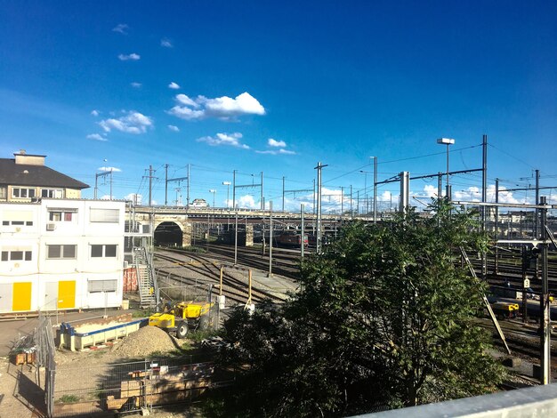 Railroad tracks in city against blue sky