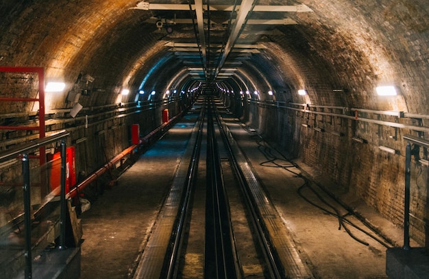 railroad tracks in illuminated tunnel