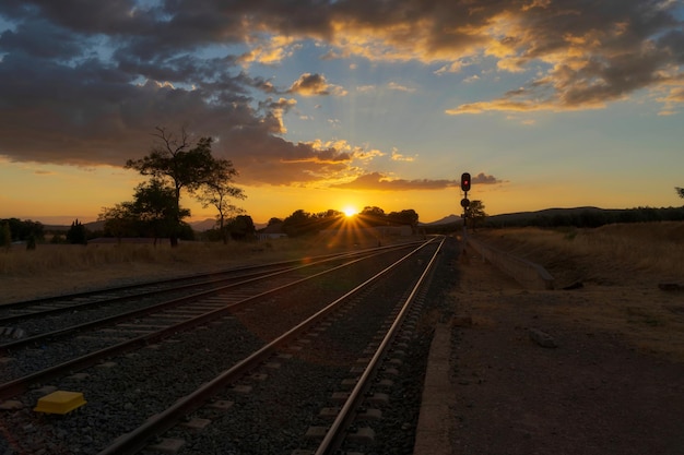 Photo railroad tracks leading into sunset