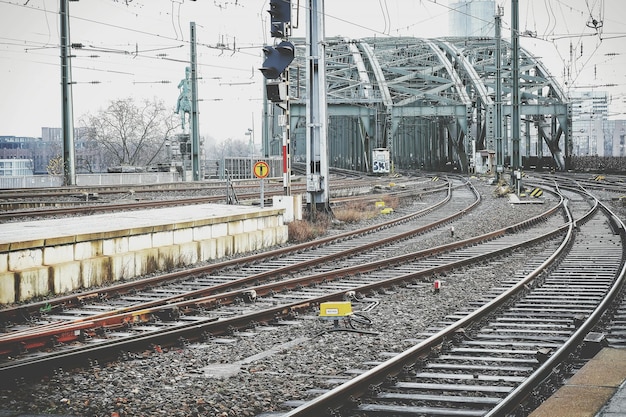 railroad tracks leading towards metallic bridge