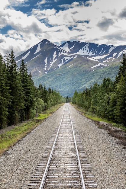 空に照らされた山へ向かう鉄道線路