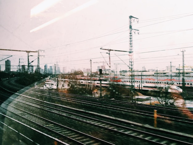 Photo railroad tracks seen through glass window with reflection