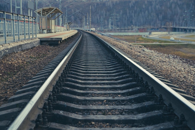 Rails die zich uitstrekken in de verte en het treinstation. Spoorvervoer, reizen, communicatie.