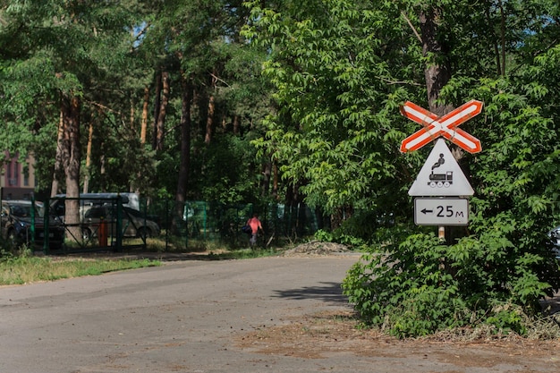 A railway crossing sign on the road