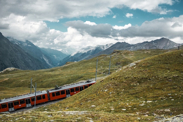 Railway in mountains and red train Zermatt Swiss Alps adventure in Switzerland Europe