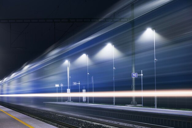 Photo railway at night light trails of passenger train at illuminated railroad station