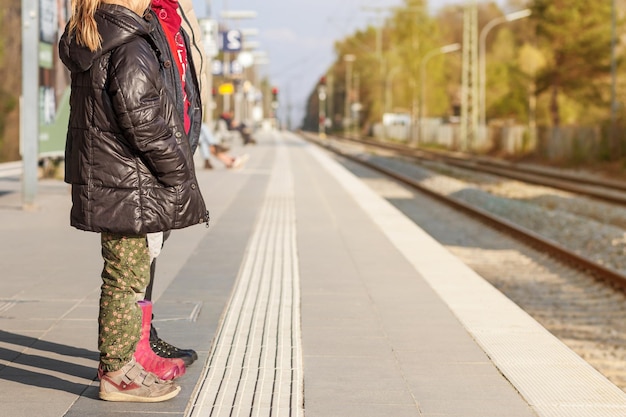 鉄道の安全。駅の子供たち。近代的な屋外鉄道駅の安全な国境。