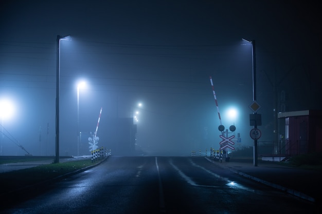 Railways crossing at foggy and wet night