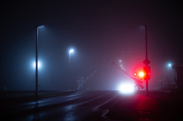 霧と雨の夜に横断する鉄道