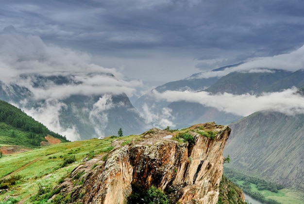 写真 山頂に雨雲。川の谷の上の切り立った崖。アルタイ