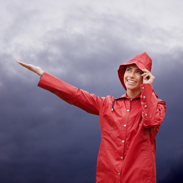 Foto cappotto di pioggia donna e sorriso con il tempo all'aperto e libertà con pausa e viaggio persona natura e ragazza con copertura e spensierata con gioia e tempesta con nebbia e bagnato con acqua felice e nuvoloso